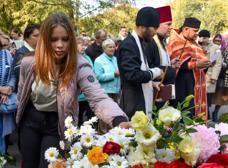 People laid flowers for the victims of the Kerch college shooting as police investigate the killer