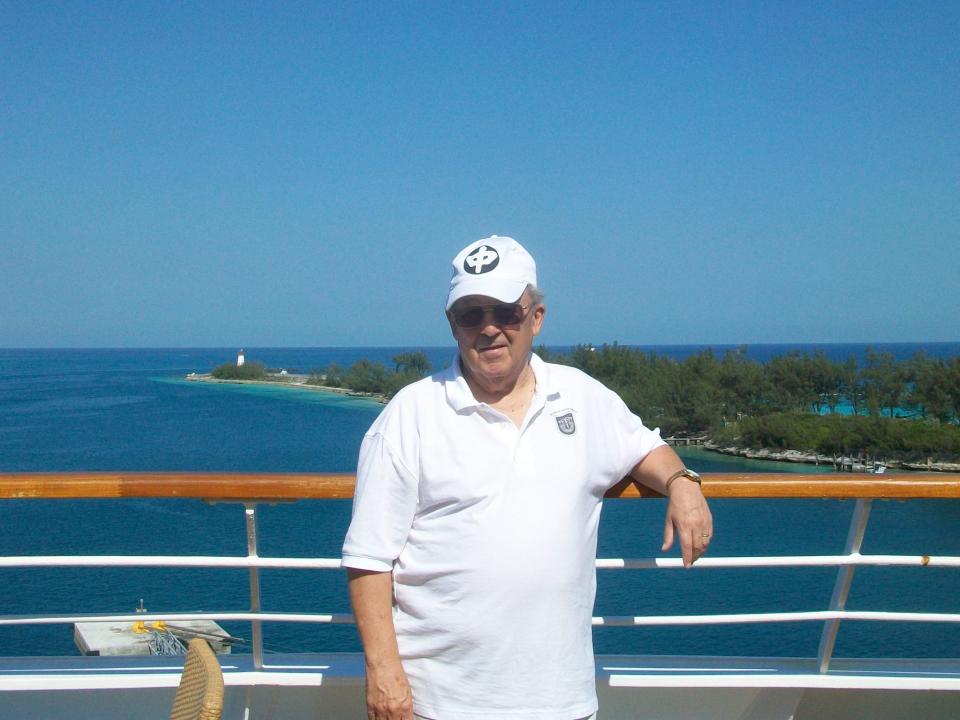 robert l willett posing for a photo on the deck of a cruise ship in front of blu skies