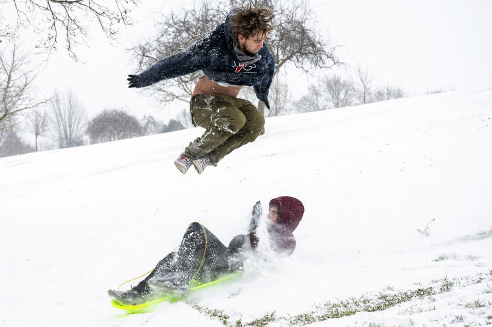 Aidin Weber, 18, of Clarkston, Wash., leaps over his younger brother, David, 13, as he sleds down a hill at Sunset Park in Lewiston, Idaho, on Friday, Feb. 12, 2021. (Pete Caster/Lewiston Tribune via AP)