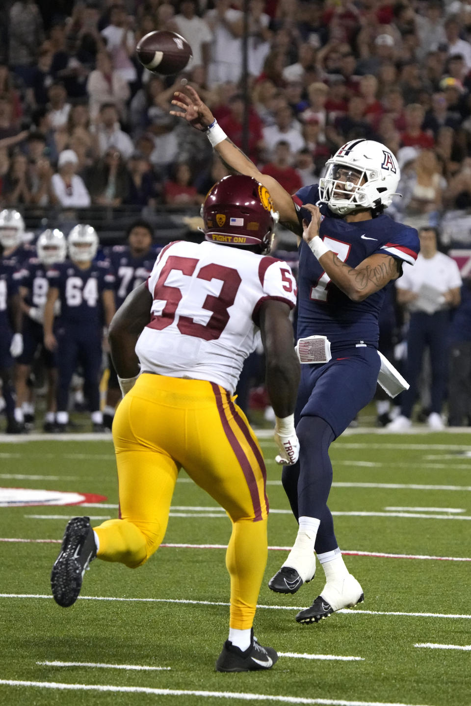 Arizona quarterback Jayden de Laura throws down field while being pressured by Southern California linebacker Shane Lee (53) in the second half during an NCAA college football game, Saturday, Oct. 29, 2022, in Tucson, Ariz. (AP Photo/Rick Scuteri)