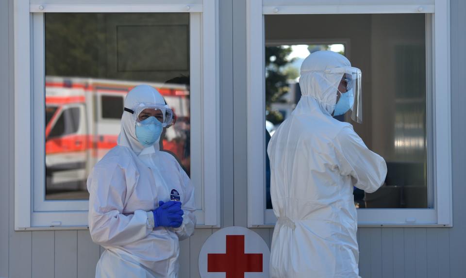 Health workers wear protective clotes while taking samples of persons arriving in their cars at a new coronavirus COVID-19 testing station for travelers from the motorway at the motorway service area Hochfelln near Ruhpolding, southern Germany, on July 30, 2020. (Photo by Christof STACHE / AFP) (Photo by CHRISTOF STACHE/AFP via Getty Images)