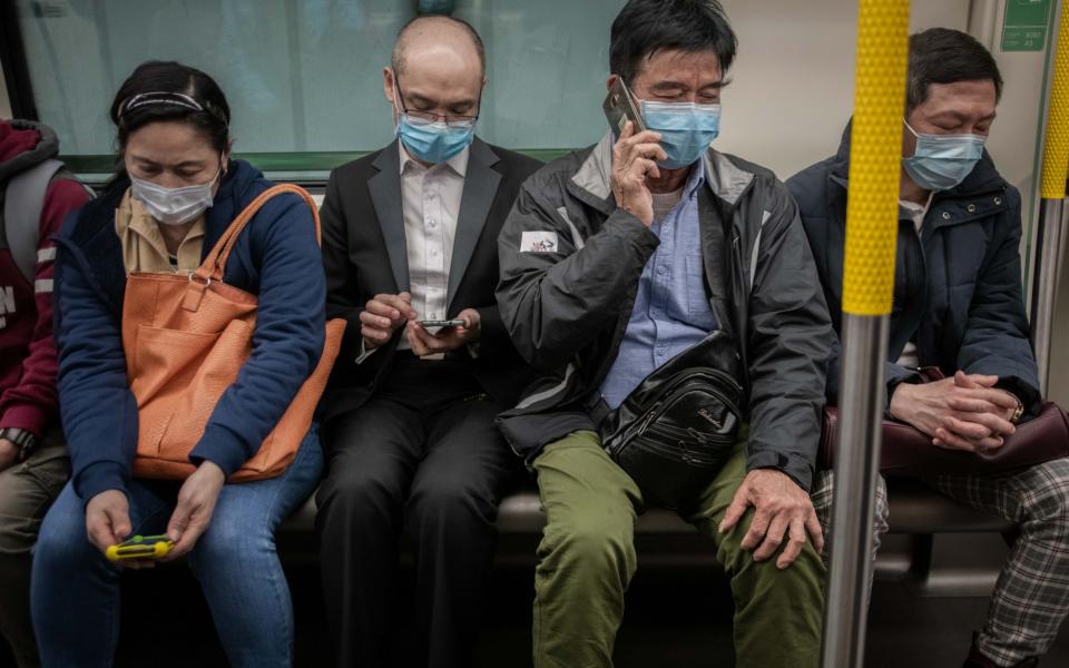 Passengers wear protective masks onboard an MTR Corp. train in Hong Kong, China - Ivan Abreu / Bloomberg