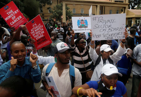 Striking doctors hold placards and chant slogans outside the Court of Appeal as they wait for the release of jailed officials of the national doctors' union in their case to demand fulfilment of a 2013 agreement between their union and the government that would raise their pay and improve working conditions in Nairobi, Kenya, February 15, 2017. REUTERS/Thomas Mukoya