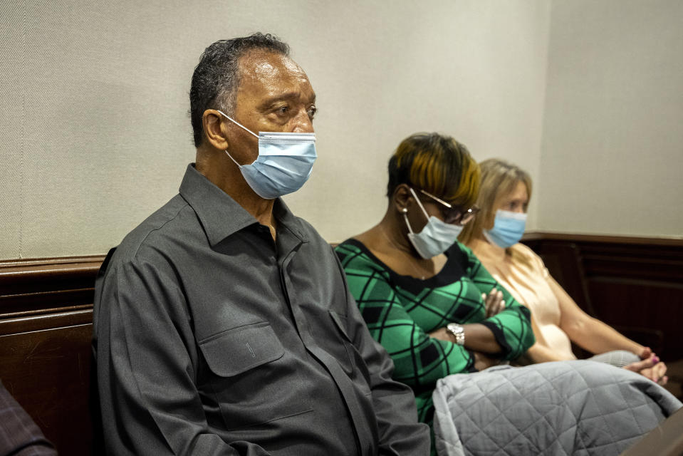 The Rev. Jesse Jackson, left, sits with Ahmaud Arbery's mother, Wanda Cooper-Jones, center, during the trial of Greg McMichael and his son, Travis McMichael, and a neighbor, William "Roddie" Bryan in the Glynn County Courthouse, Monday, Nov. 15, 2021, in Brunswick, Ga. The three are charged with the February 2020 slaying of 25-year-old Ahmaud Arbery. (AP Photo/Stephen B. Morton, Pool)