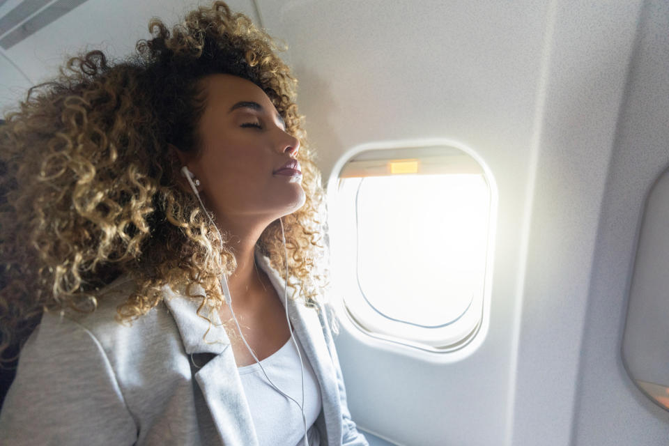 Woman trying to relax on a plane. (Getty Images)