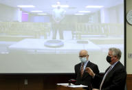 Defense attorney Mark Collins, right, speaks to the judge as defense attorney Steve Nodler, center, listens during the arraignment of former Franklin County, Ohio, deputy Jason Meade, appearing on video screen in Columbus, Ohio, Friday, Dec. 3, 2021. Meade, who fatally shot Casey Goodson Jr. in the back five times has pleaded not guilty to charges of murder and reckless homicide. (AP Photo/Paul Vernon)