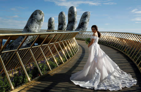 A Vietnamese bride poses for her wedding photos on Gold Bridge on Ba Na hill near Danang city, Vietnam August 1, 2018. REUTERS/Kham