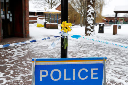 Flowers are left at the cordon near the tent covering the park bench where former Russian intelligence officer Sergei Skripal and his daughter Yulia were found poisoned in Salisbury, Britain, March 19, 2018. REUTERS/Peter Nicholls