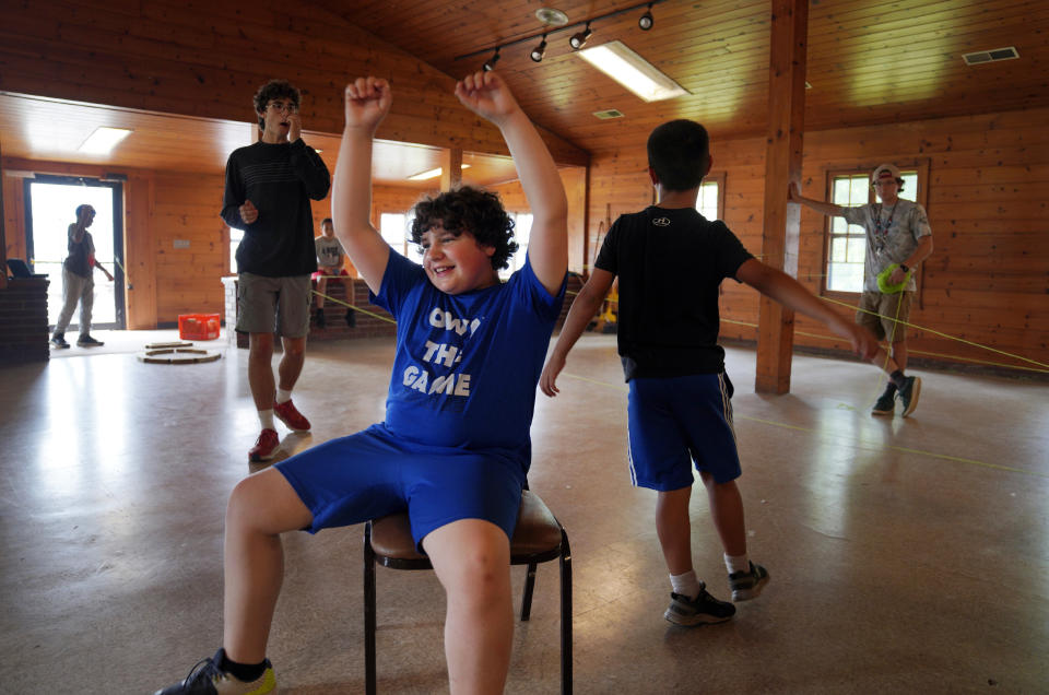 Elias Farley, center, cheers after winning a game of musical chairs at the YMCA Camp Kon-O-Kwee Spencer on Thursday, June 29, 2023, in Zelienople, Pa. Due to the poor air quality caused by the Canadian wildfires the Western Pennsylvania summer camp closed its outdoor pool, transitioned to indoor activities and sent home a few campers with health problems. (AP Photo/Jessie Wardarski)