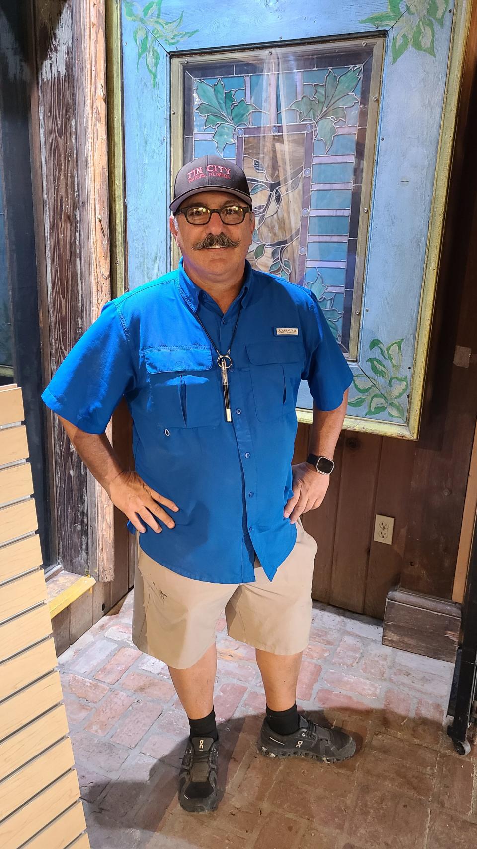 Tin City's property manager Craig Ekonomos in front of a framed stained glass artifact discovered during complex's cleanup and refurbishment.