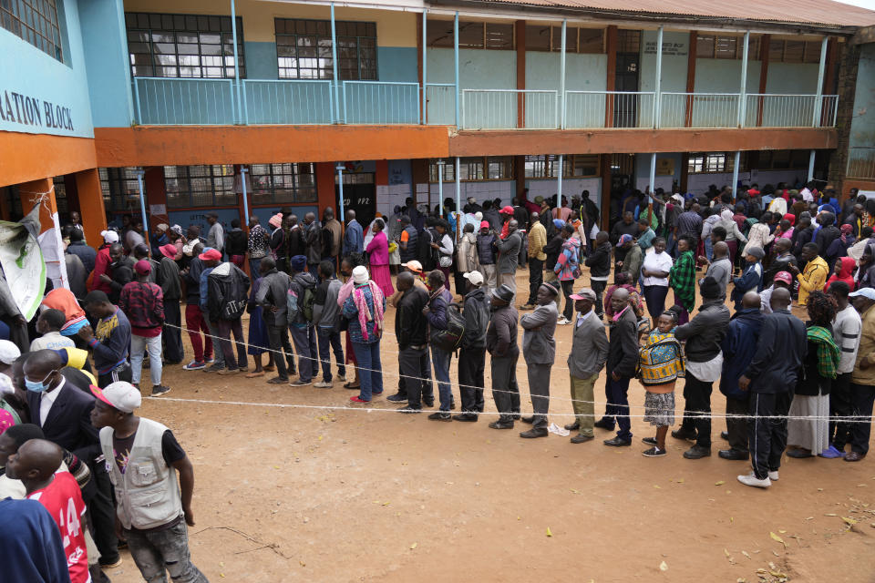 People line up to vote at the Gatina Primary School in Nairobi, Kenya, Tuesday, Aug. 9, 2022. Kenyans are voting Tuesday in an unusual presidential election, where a longtime opposition leader who is backed by the outgoing president faces the brash deputy president who styles himself as the outsider and a “hustler.” (AP Photo/Khalil Senosi)