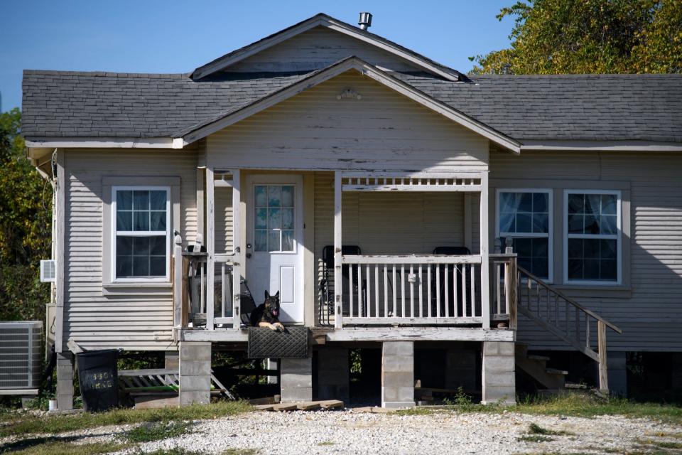 A dog lies on the porch of a home roughly a mile from K-Solv's Jacintoport facility.