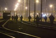 Migrants walk on the railway tracks of the freight shuttle leading to the entrance of the Channel Tunnel in Calais, France, October 14, 2015. REUTERS/Philippe Wojazer