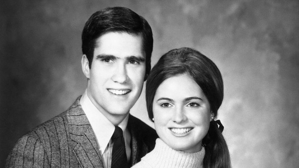 a black and white photo of a young mitt romney, wearing a patterned suit, and ann lois davies, wearing a turtleneck sweater