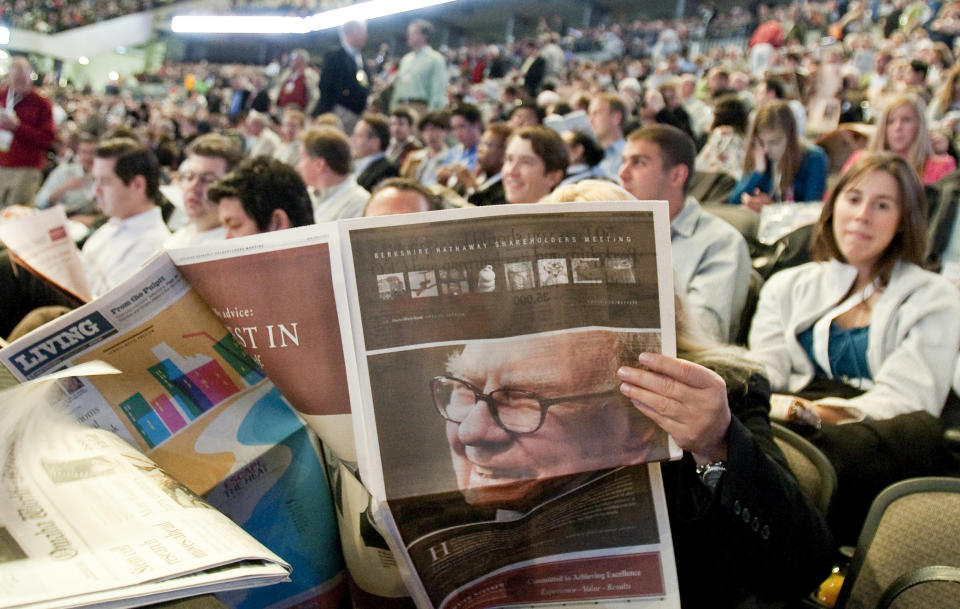 The picture of Berkshire Hathaway Chairman and CEO Warren Buffett is seen in a newspaper in Omaha, Neb., Saturday, May 1, 2010, as shareholders pack the Qwest Center arena well ahead of the shareholders meeting start time.(AP Photo/Nati Harnik)