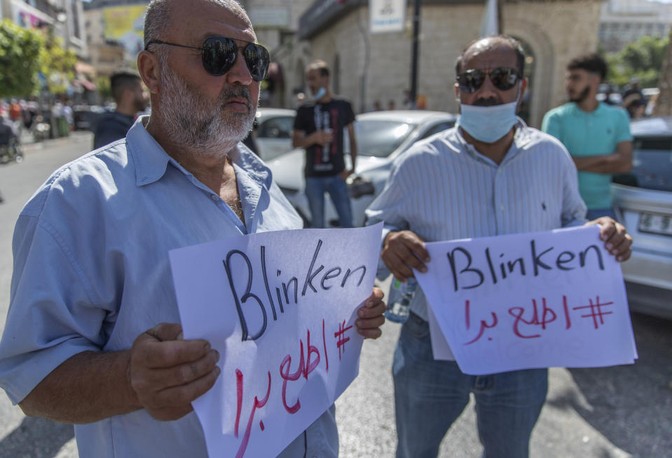 Palestinians hold signs that read: "Blinken, get out," during a protest against the visit of U.S. Secretary of State Antony Blinken and meeting with Palestinian President Mahmoud Abbas, in the West Bank city of Ramallah, Tuesday, May 25, 2021. Blinken has vowed to "rally international support" to aid Gaza during a visit to Israel at the start of a regional tour to shore up last week's cease-fire. (AP Photo/Nasser Nasser)