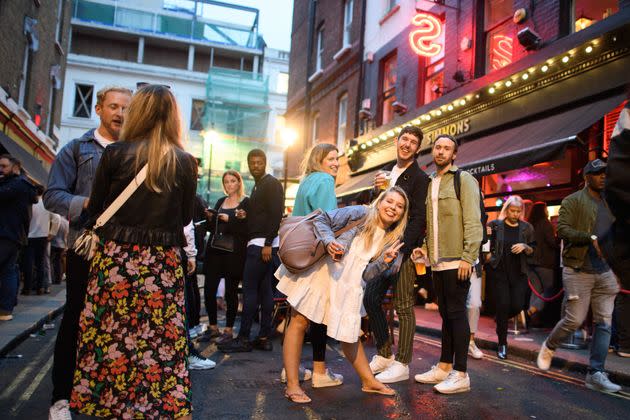 People eat and drink outdoors in Soho, London, as coronavirus lockdown restrictions are eased across England. 