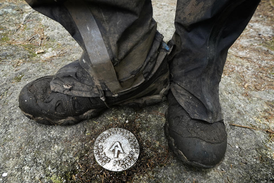 M.J. Eberhart, 83, pauses by a survey marker on the Appalachian Trail, Sunday, Sept. 12, 2021, in Gorham, New Hampshire. Eberhart, who goes by the trail name of Nimblewill Nomad, has hiked all of the country's major long-distance trails. He has also walked the length of Route 66 from Illinois and California. (AP Photo/Robert F. Bukaty)