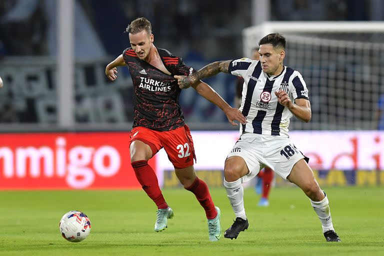 Una escena de un Talleres vs. River en Córdoba: Villagra lucha por la pelota con Tomás Pochettino