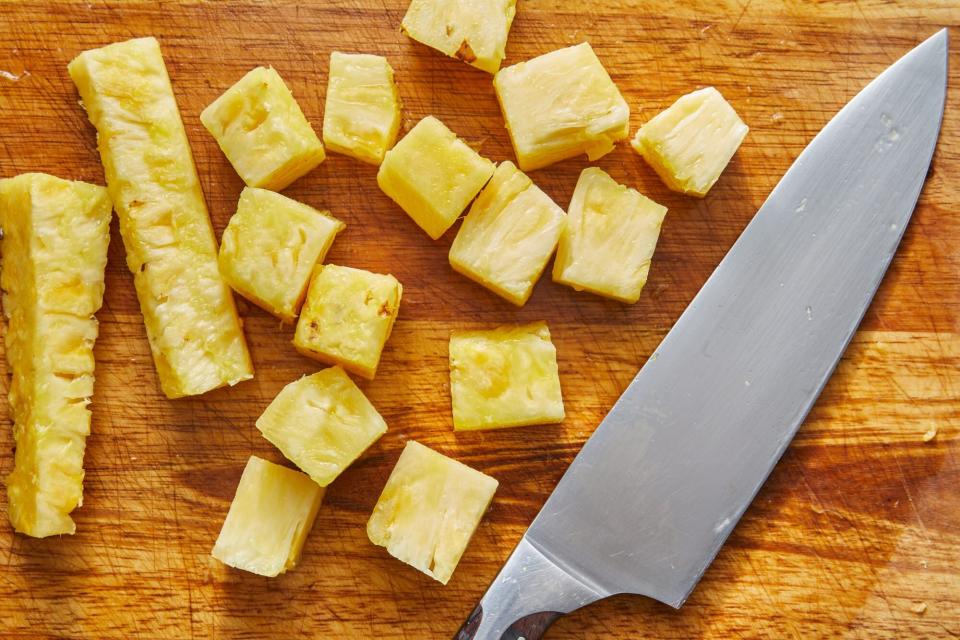 slicing pineapple spears into chunks