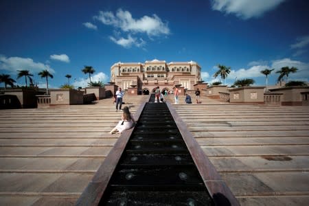 FILE PHOTO: Tourists take photos at the entrance of the Emirates Palace Hotel in Abu Dhabi