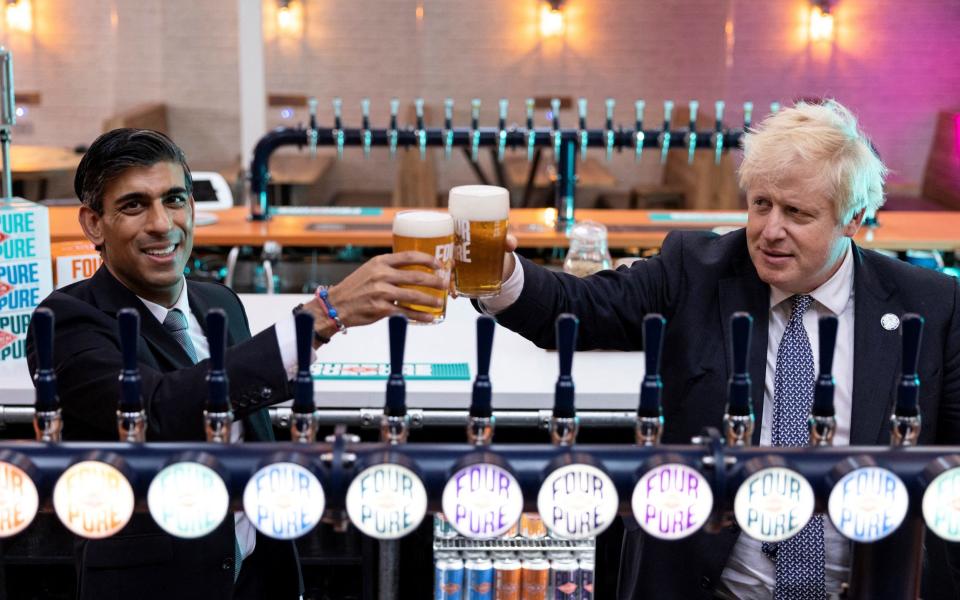 Boris Johnson (R) and Britain's Chancellor of the Exchequer Rishi Sunak raise a pint as they visit Fourpure Brewery in Bermondsey, south London