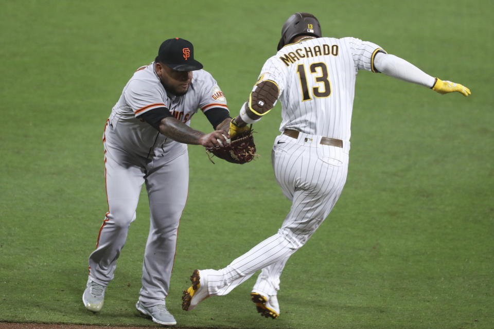 San Francisco Giants relief pitcher Reyes Moronta tags out San Diego Padres' Manny Machado during the sixth inning of a baseball game Tuesday, April 6, 2021, in San Diego. (AP Photo/Derrick Tuskan)