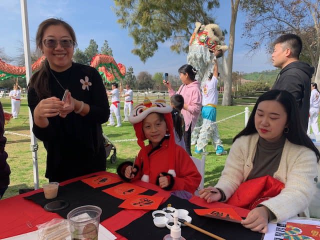 華人媽媽帶孩子參加過年活動寫春聯。（記者楊青/攝影）