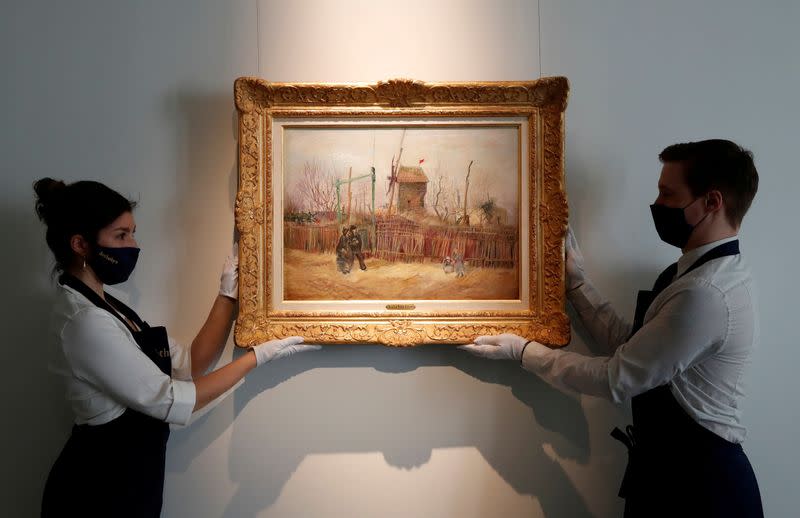 FILE PHOTO: Sotheby's Paris employees pose with the painting "Scene de rue a Montmartre" by Dutch painter Vincent Van Gogh