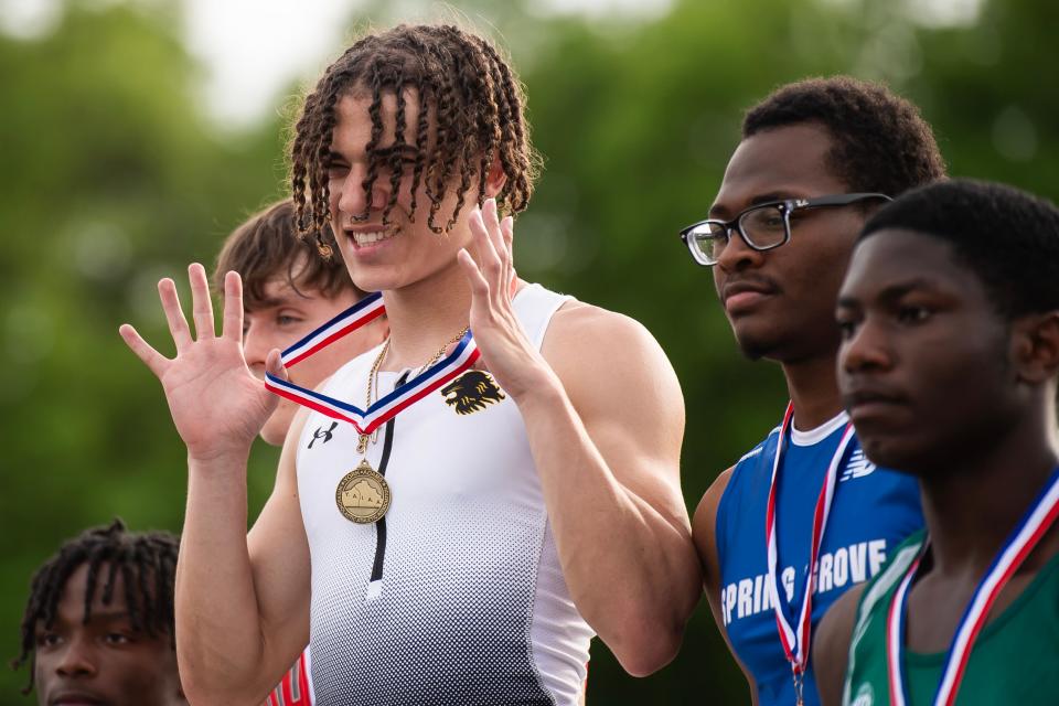Red Lion senior LaDainian Strausbaugh holds up his gold medal on the awards podium after winning the 100-meter dash (10.84) during the YAIAA Track and Field Championships at Dallastown Area High School on May 8, 2024.