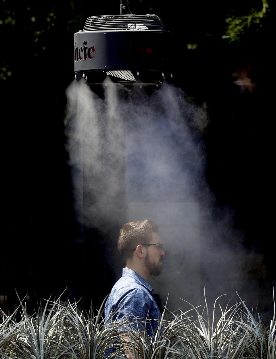 <p>A man stands under a misting machine, June 19, 2017 in Tempe, Ariz. The forecast calls for a high of 118 on Monday and 120 on Tuesday in Phoenix. (Matt York/AP) </p>