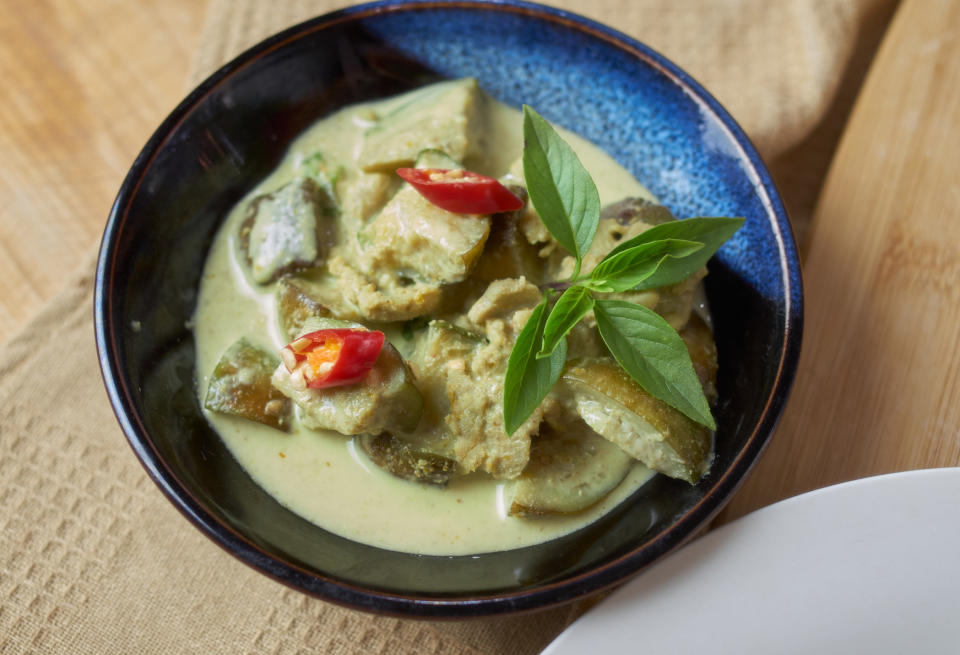 A spicy curry dish garnished with a leaf