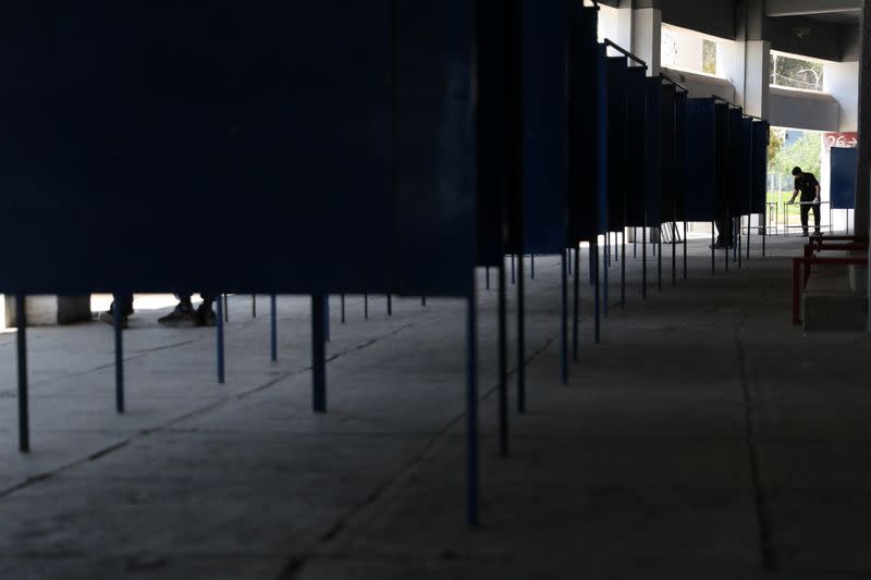 A worker places voting booths inside a polling station ahead of the upcoming referendum on a new Chilean constitution in Santiago