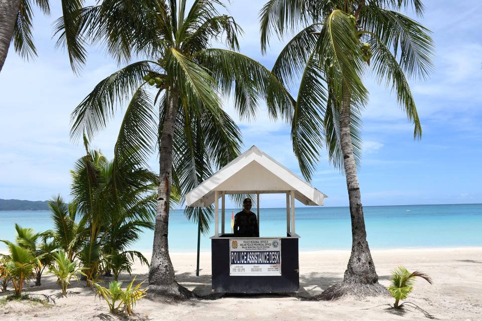 FILE PHOTO: This photo taken on June 17, 2020 shows a policeman standing guard along the empty famous white beach of Boracay Island in central Philippines, as community quarantine against COVID-19 still continues throughout the country, with foreign tourists still banned on beaches. (Photo: ERNESTO CRUZ/AFP via Getty Images)