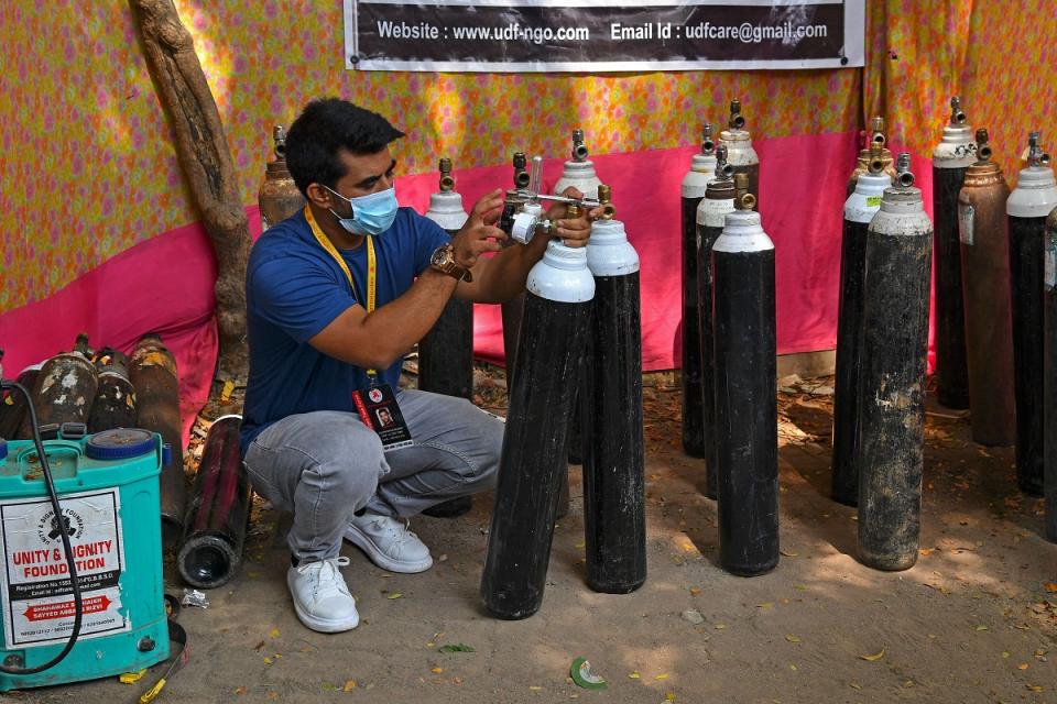 Mumbai resident Shahnawaz Shaikh, who sold his SUV car to raise funds in order to start free service to provide oxygen cylinders to the needy people amid Covid-19 checks the pressure of an oxygen cylinder at a distribution centre in a slum in Mumbai on April 28, 2021. (Photo by Indranil MUKHERJEE / AFP) (Photo by INDRANIL MUKHERJEE/AFP via Getty Images)