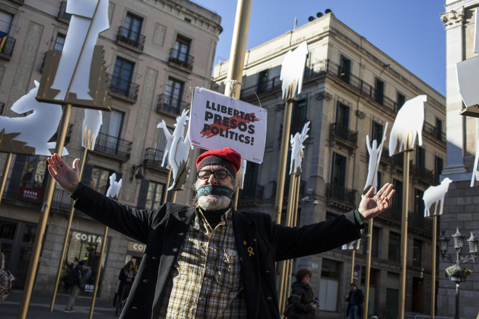 A man stands next to a banner reading in Catalan,”Freedom for Political Prisoners,” in support of Catalan politicians who have been jailed on charges of sedition, in Barcelona Dec. 19. (Photo: Jose Colon/MeMo for Yahoo News)