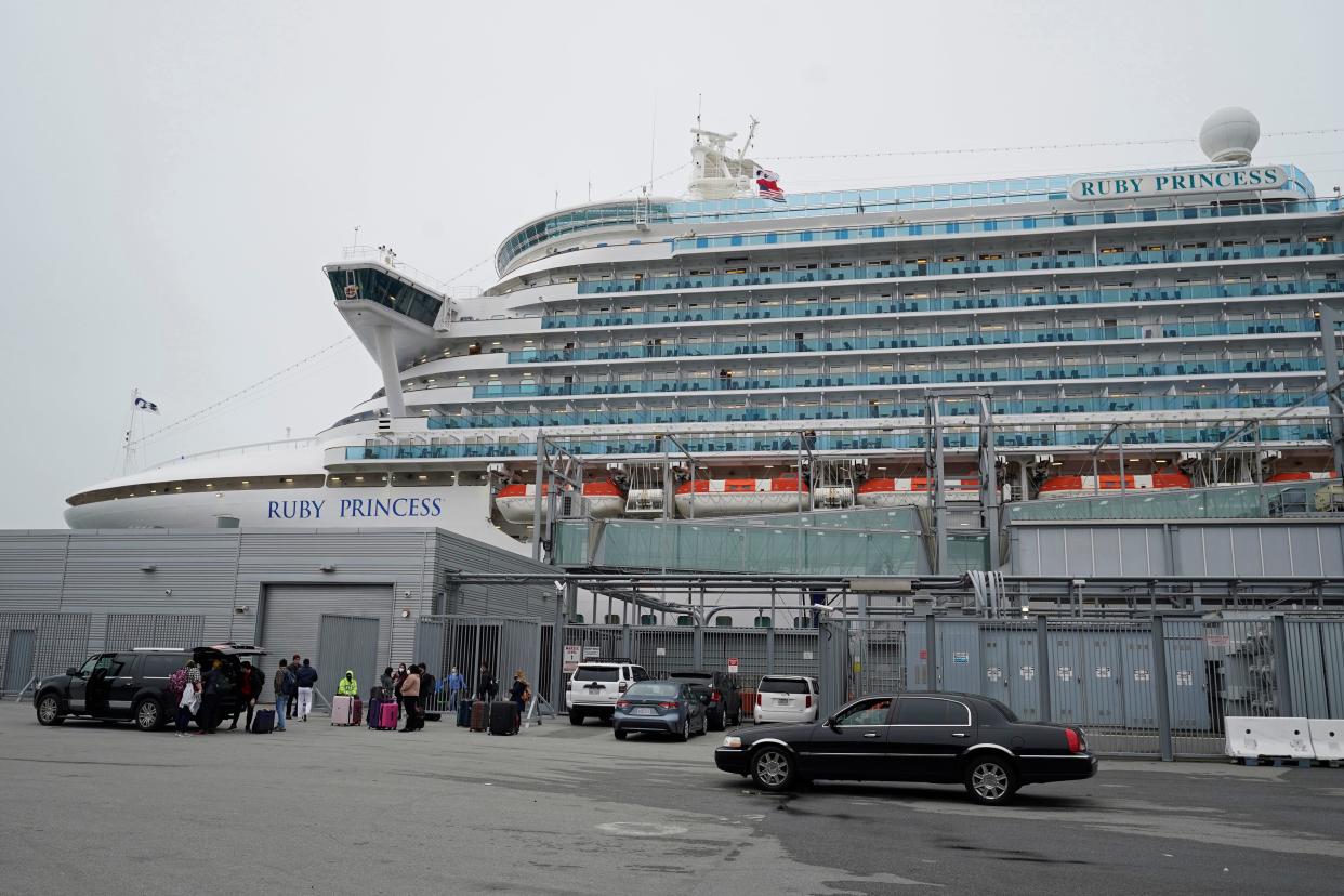 People stand on a pier outside the Ruby Princess cruise ship and wait to be picked up in San Francisco, Thursday, Jan. 6, 2021.