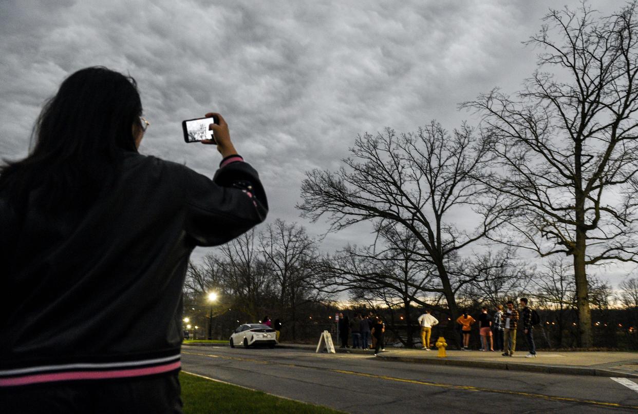 University of Rochester student Lucy Liu takes a photo of the clouds just as the Eclipse passed peak totality at the University of Rochester in Rochester on Monday, April 8, 2024.