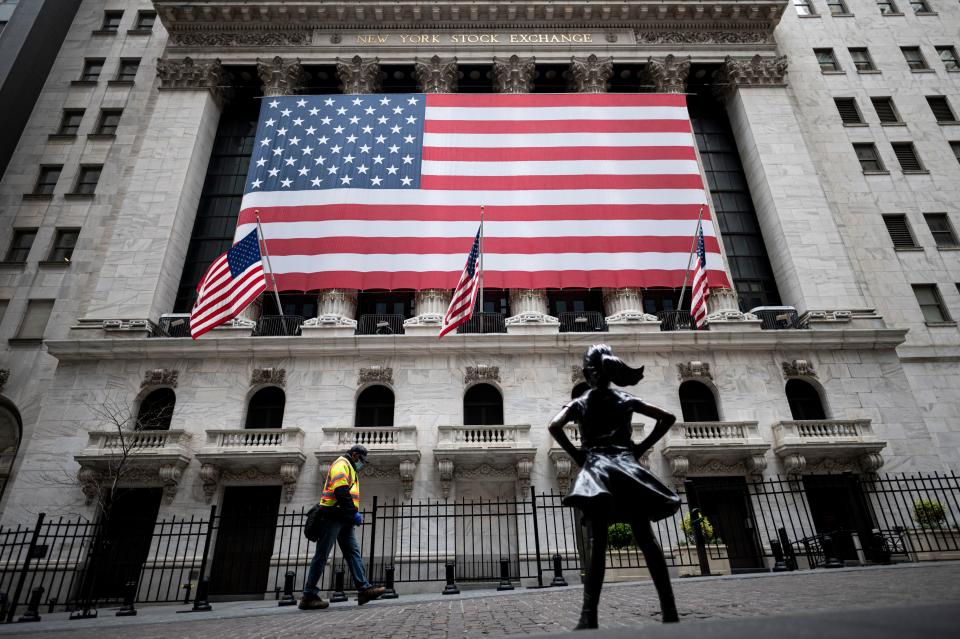 The fearless girl statue and the New York Stock Exchange (NYSE) are pictured on April 20, 2020 at Wall Street in New York City. - Wall Street opened lower on Monday as traders grappled with a drop in oil prices to 22-year lows as the coronavirus pandemic sapped demand for energy. The Dow Jones Industrial Average was down 1.8 percent to 23,798.01 about 10 minutes into the trading session.The broad-based S&P 500 had declined 1.3 percent to 2,835.08, while the tech-rich Nasdaq had fallen 0.7 percent to 8,588.66. (Photo by Johannes EISELE / AFP) (Photo by JOHANNES EISELE/AFP via Getty Images)