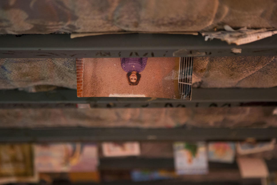 In this April 11, 2014 photo, photographs and keepsakes are wedged between the top bunk mattress and bed frame in the bedroom of Martin Camarillo, 35, during a theater show in Mexico City's Tepito neighborhood. Organizers and attendees of the theater project reject the idea they are exploiting the residents’ lives for their own entertainment, saying “Safari in Tepito” aims to increase understanding of the poor in a country where nearly 50 percent of the population lives below the poverty line. (AP Photo/Rebecca Blackwell)