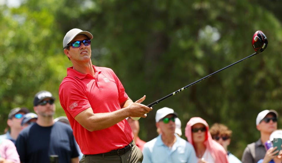   Scott watches his tee shot while holding a driver 