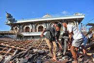 <p>People recover a motorcycle from a damaged home near a mosque after a strong earthquake in Gunungsari, West Lombok, Indonesia, Aug. 6, 2018. (Photo: Antara Foto/Ahmad Subaidi via Reuters) </p>