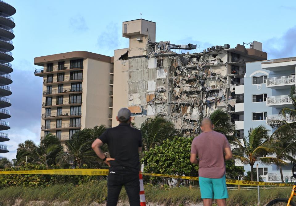 Onlookers look at the damage at the 12-story oceanfront Champlain Towers South Condo.