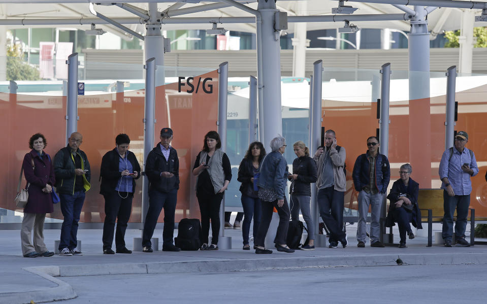 Commuters wait in lines for buses at the Temporary Transbay Terminal after the Salesforce Transit Center was closed Tuesday, Sept. 25, 2018, in San Francisco. San Francisco officials shut down the city's celebrated new $2.2 billion transit terminal Tuesday after discovering a crack in a support beam under the center's public roof garden. Coined the "Grand Central of the West," the Salesforce Transit Center opened in August near the heart of downtown after nearly a decade of construction. It was expected to accommodate 100,000 passengers each weekday, and up to 45 million people a year. (AP Photo/Eric Risberg)