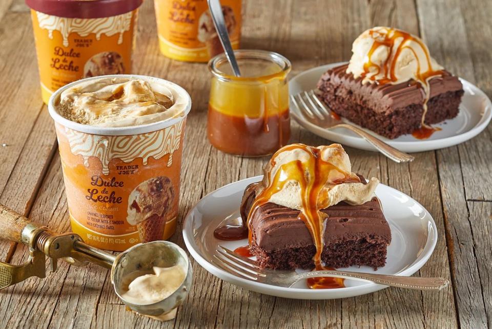 trader joe's dulce de leche ice cream on top of pieces of chocolate mini sheet cake, and caramel sauce drizzle