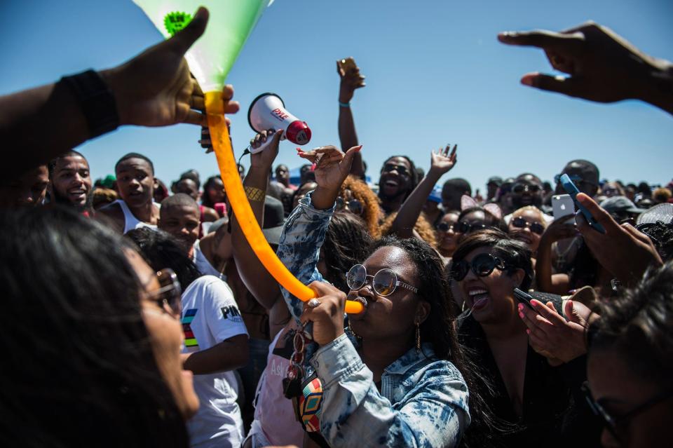 A crowd of partiers cheer for a lady taking a beer bong during Orange Crush on Tybee Island in this file photo.