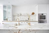 <p>Marble is the classic choice for a white kitchen, adding texture and warmth that breaks up a pure white palette. Solid blocks of marble across kitchen countertops, splashbacks, and shelving is as luxurious as it is impactful, especially with matte brass finishes. </p><p>Pictured: <a href="https://www.blakeslondon.com/west-london/" rel="nofollow noopener" target="_blank" data-ylk="slk:Kitchen by Blakes London;elm:context_link;itc:0;sec:content-canvas" class="link ">Kitchen by Blakes London</a></p>