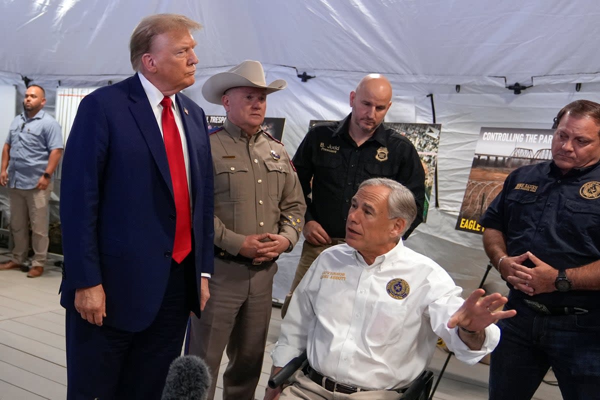 Mr Trump was met by Texas Governor Greg Abbott (AP)