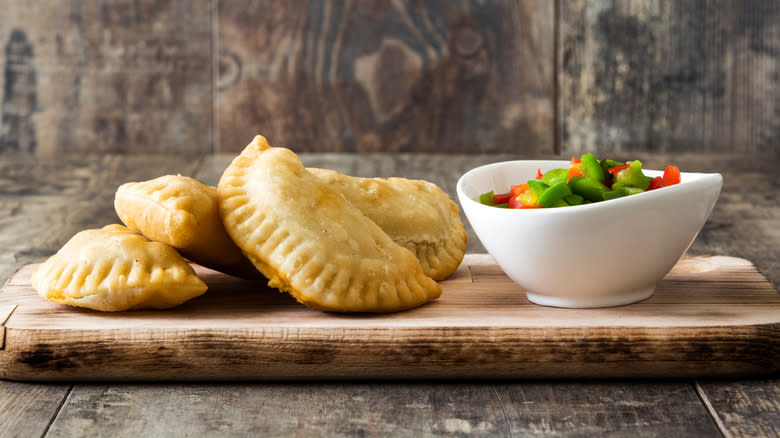 Empanadas with a bowl of chopped bell peppers
