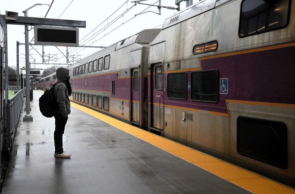 Marquis Browder watches as an MBTA commuter train pulls to a stop at the new Pawtucket-Central Falls station on Monday, the opening day of commuter rail service to Boston. Browder was heading to work in Boston on Monday morning.